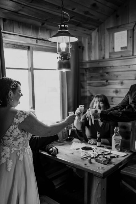 The couple and their parents toast with orange juice inside the cabin.