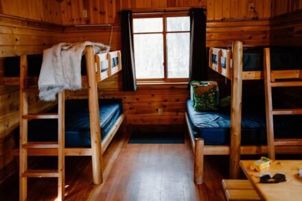 The bunk beds inside the cabin with rustic log frames.