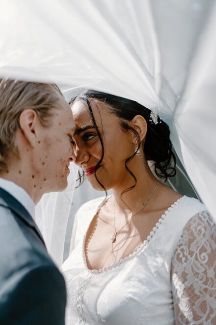 Claire and Tom press their foreheads together sweetly underneath her veil.