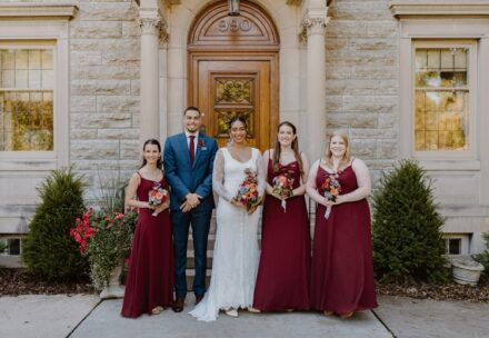 Claire, her bridesmaids, and bridesman standing in a line in front of the St. Paul College Club.