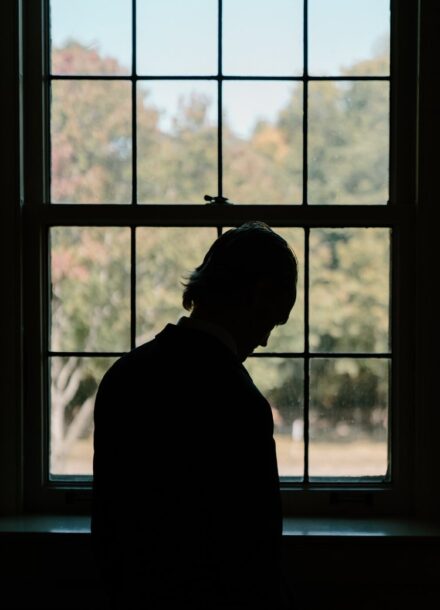 Tom's silhouette against a window leading downstairs as he heads to the first look location.