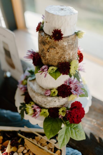 A cake made of wheels of cheese covered in wildflowers.