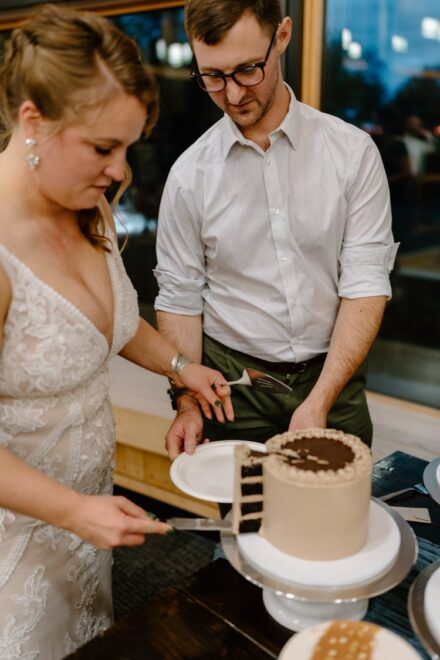 Laura and Joe working together to slice their 9 different wedding cakes.