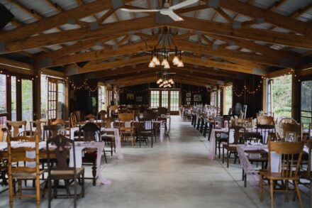 The dining area is set up with mismatched antique chairs in an old building with sliding glass doors.