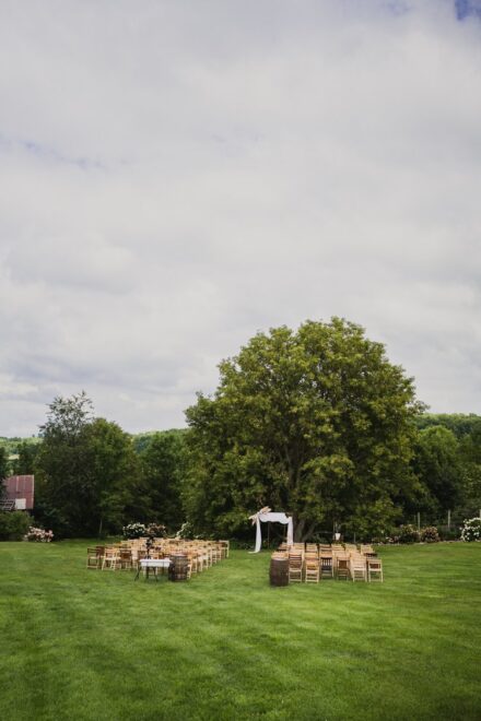 A wide angle view of the wedding ceremony space in front of a large oak tree.