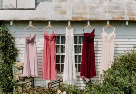 The bride's wedding dress and bridesmaid's dresses hanging on the building outside of the bride's suite.