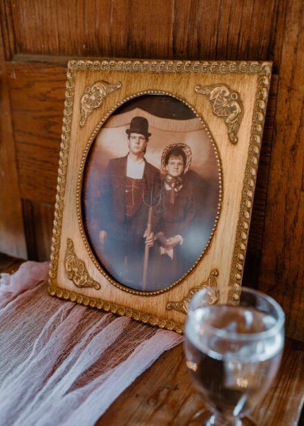A cheesy old fashioned sepia photograph of Jake's parents in a gold frame sitting on a table during the reception.