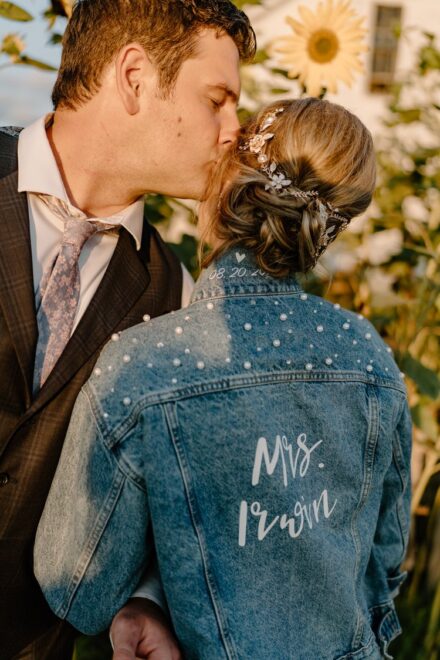 Jake kisses Sarah on the temple, her back facing the camera to show off her new "Mrs. Irwin" denim jacket.