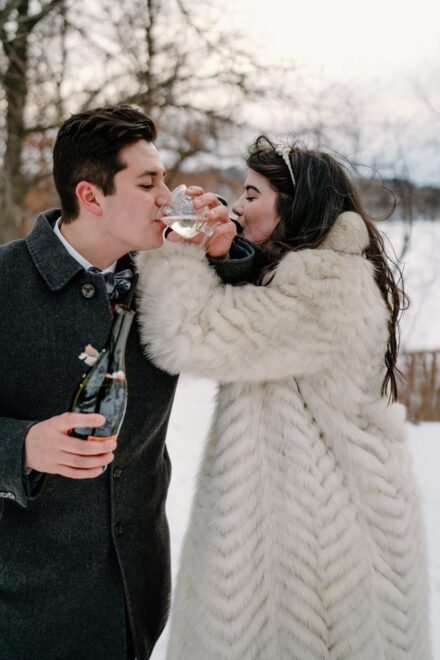 A bride and groom drinking champagne after their elopement in Stillwater, Minnesota.