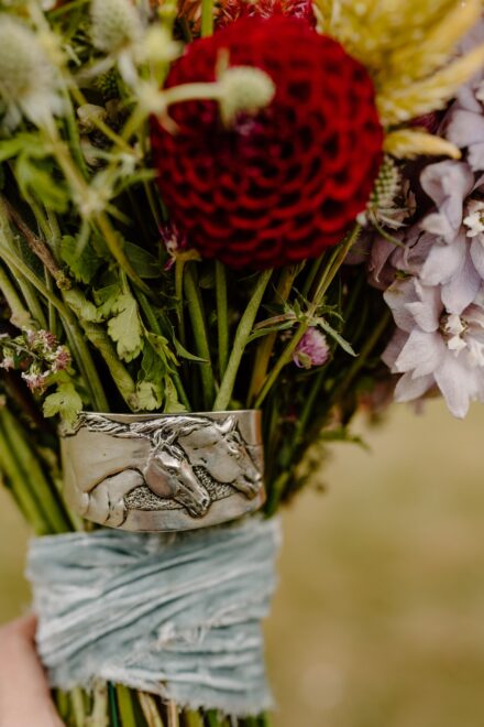 A piece of jewelry tucked into a bridal bouquet as a memorial to the bride's mom.