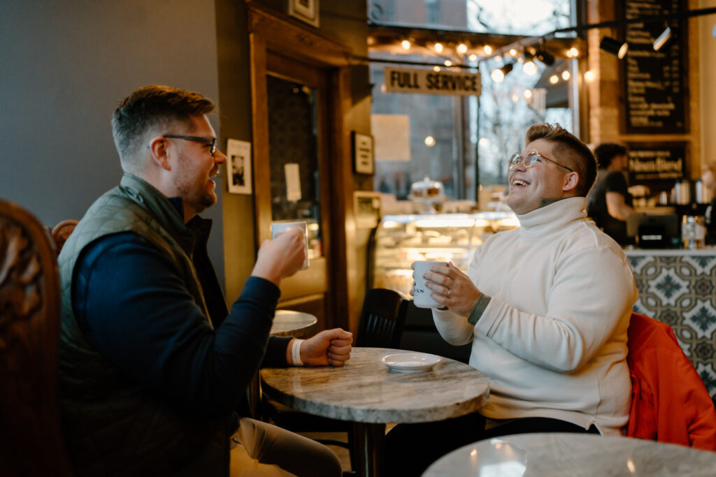 A gay couple drinking coffee and laughing at Nina's Coffee Cafe in St. Paul, Minnesota.