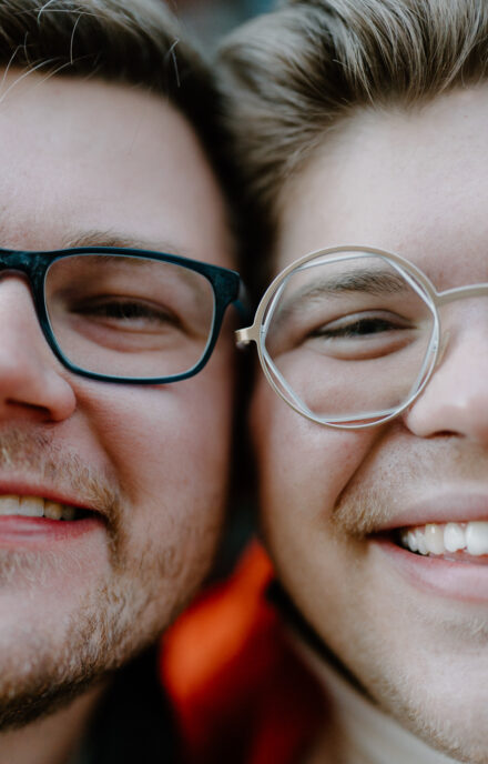A close up shot of Andy and Marko's faces pressed together side by side, highlighting their unique glasses.