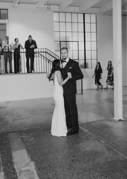 A black and white photo of the bride and groom during their first dance.