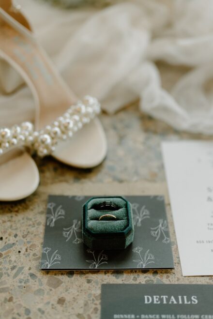 Kate Spade heels with pearls, green velvet ring box, and wedding invitations.