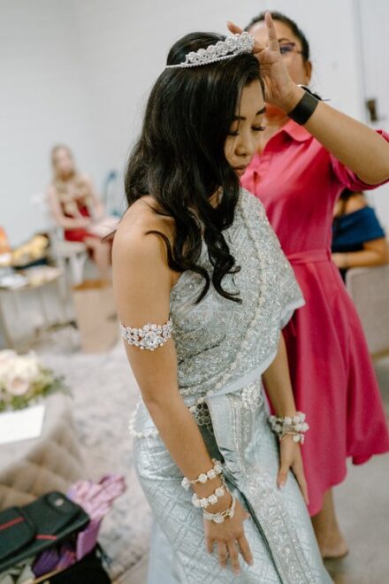 A crown being placed on the head of the bride in her Khmer wedding attire.