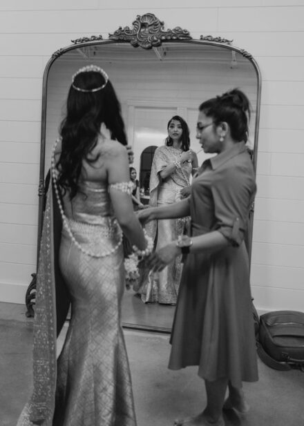 The bride looking at herself in a mirror in her Khmer wedding attire at The Whim.