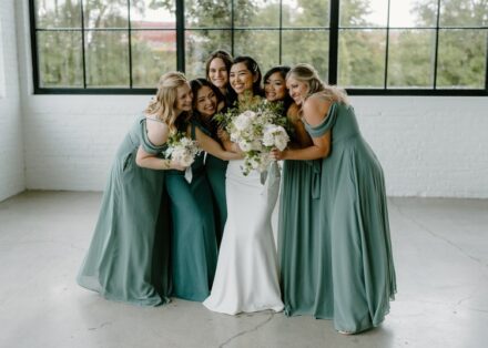 bridesmaids hugging the bride and smiling at The Whim.