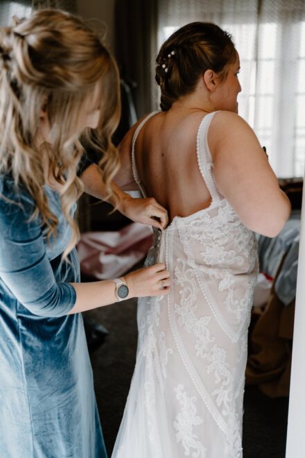 Laura's older sister zipping up her wedding dress.