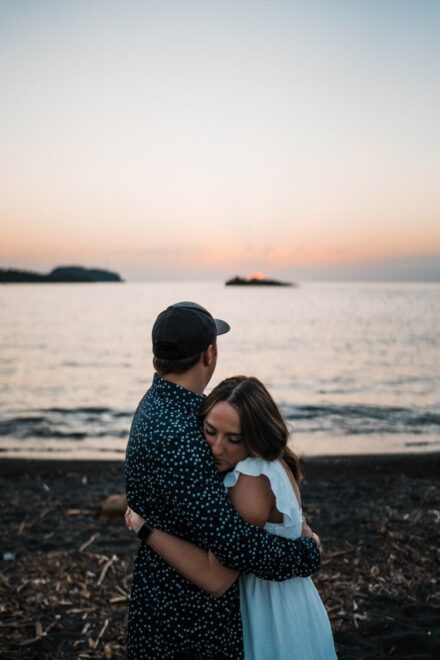 Taylor hugs Jesse in front of Lake Superior at sunrise.