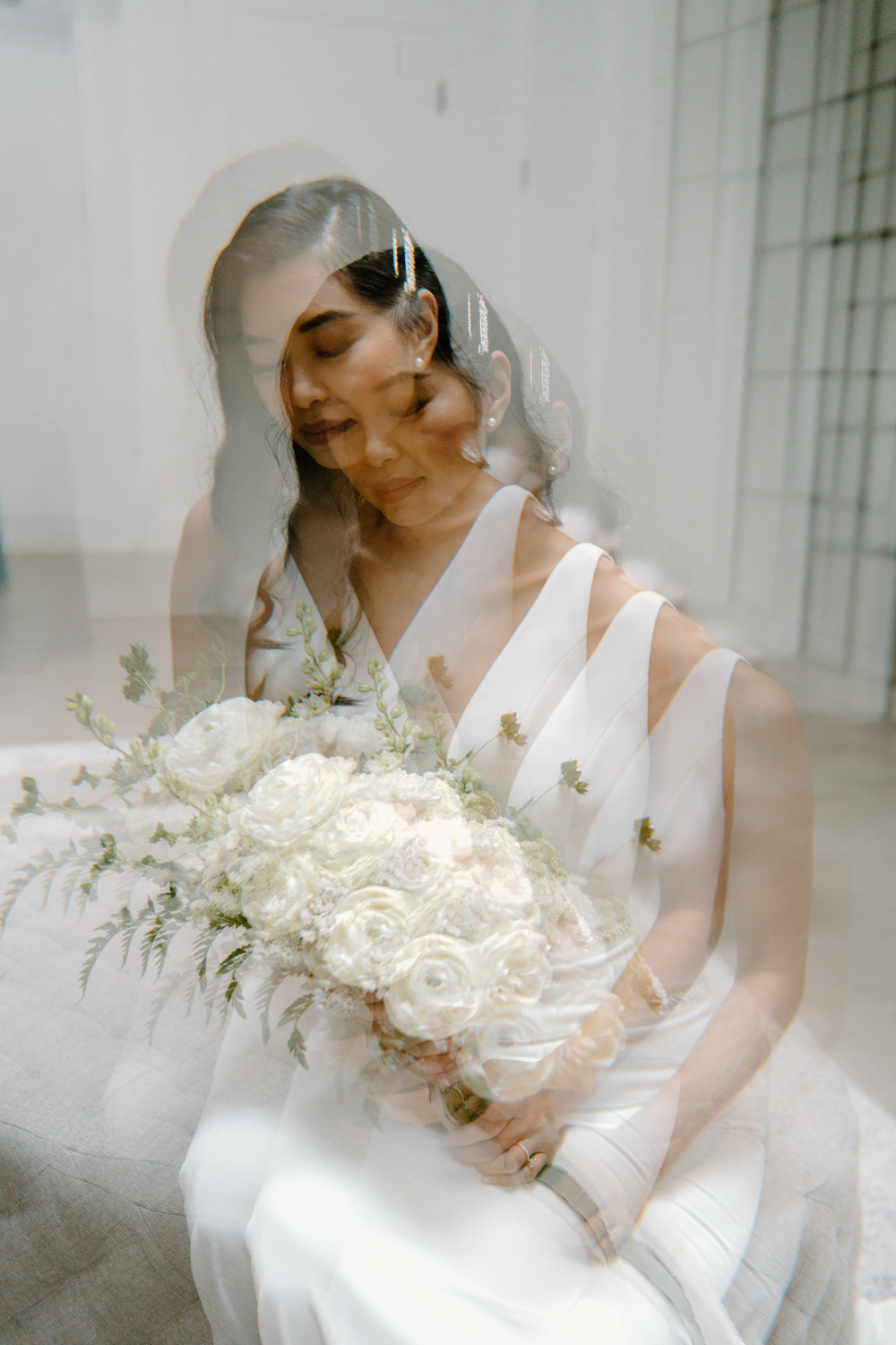 An image of a bride looking down at her bouquet taken through a linear prism on her wedding day in Minneapolis.