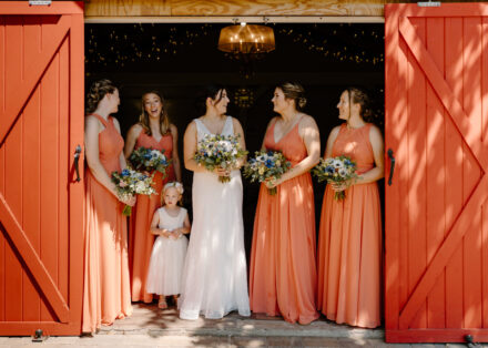 Bridesmaids in salmon pink wedding dresses at Minnetonka Orchard.