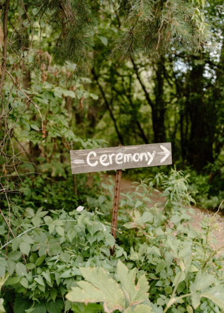 A rustic wooden sign that reads "Ceremony" points the way to the gazebo.