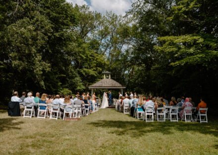 A wide angle shot of the guests and gazebo at the ceremony.