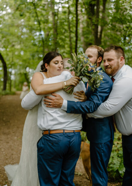 Anna and Jason receive a group hug from the groomsmen after the ceremony.