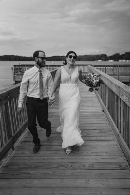 Anna and Jason run down a wooden dock together.