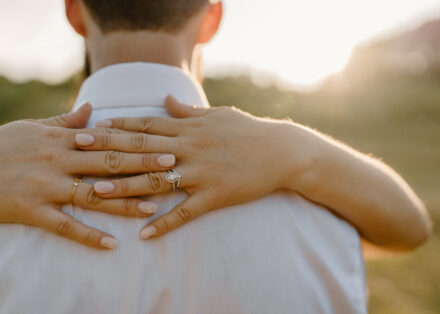 A close up of Anna's wedding rings as she wraps her arms around Jason's neck.