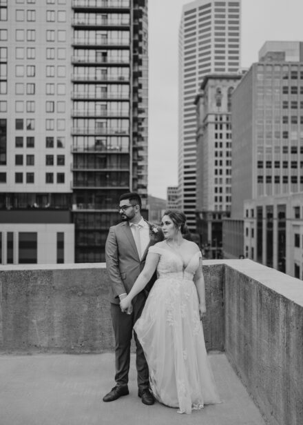 A black and white image of the couple looking off into the distance on the rooftop.