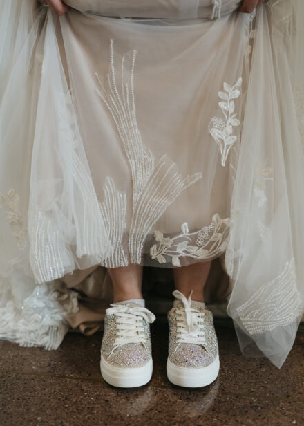 The bride shows off her sparkly tennis shoes under her dress.