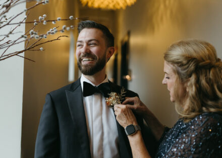 Matt laughs as his mother pins on his boutonniere.