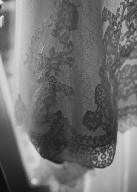 A close up black and white detail shot of the lace on Beth's wedding dress.