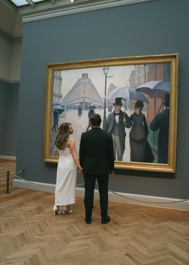 A couple gazes at each other in front of an impressionist gallery at the Art Institute of Chicago.