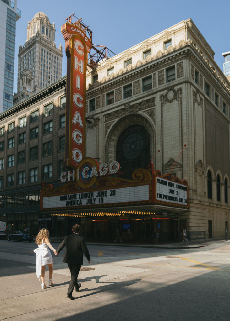 The couple walks across the street toward the Chicago Theater.