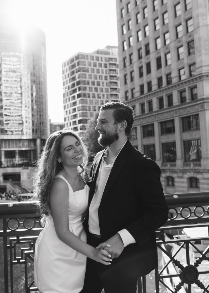 The couple laughs together overlooking the Chicago River.