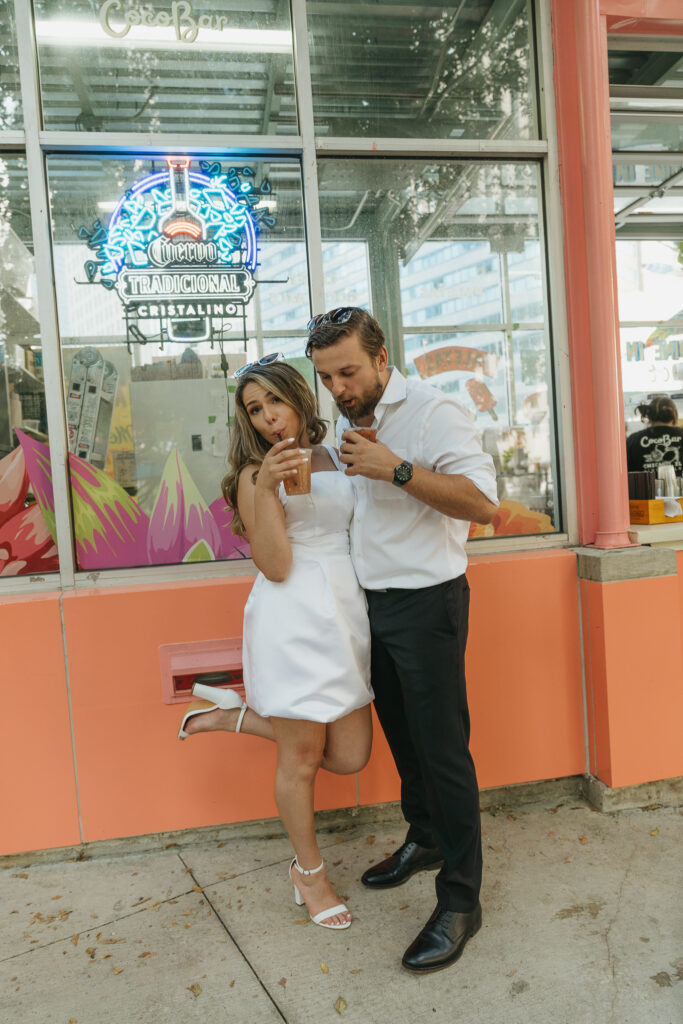 The couple sips margaritas together on a colorful restaurant patio.