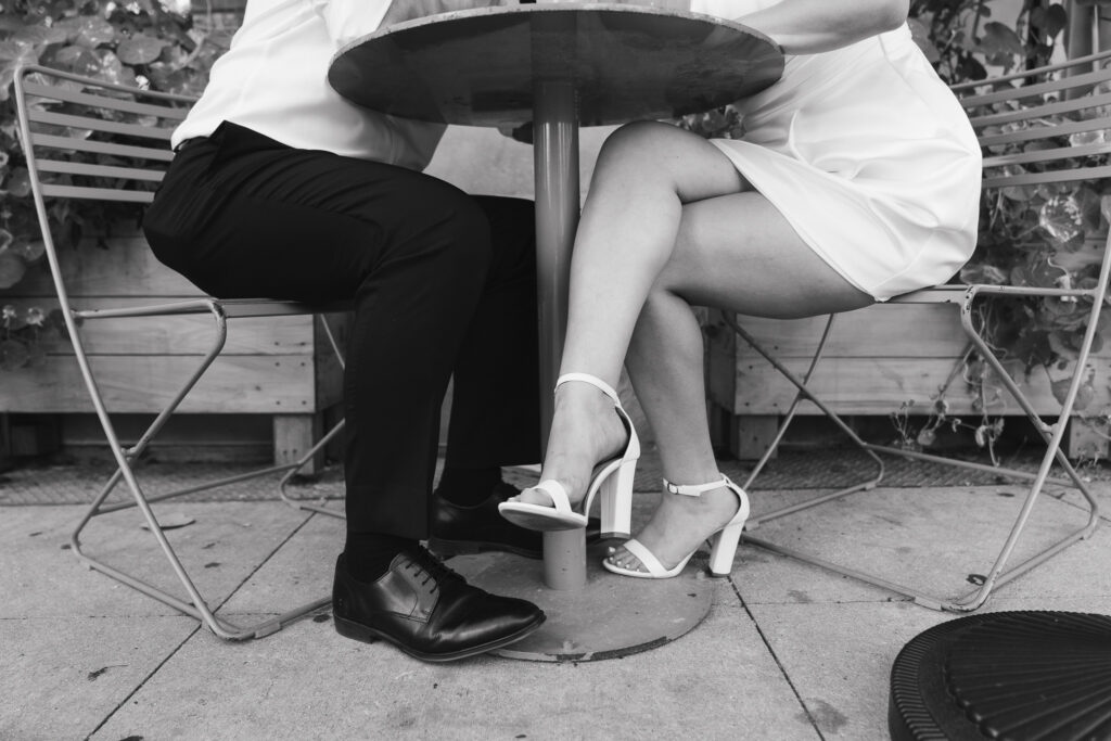 A close up of the couple's shoes underneath the restaurant table.