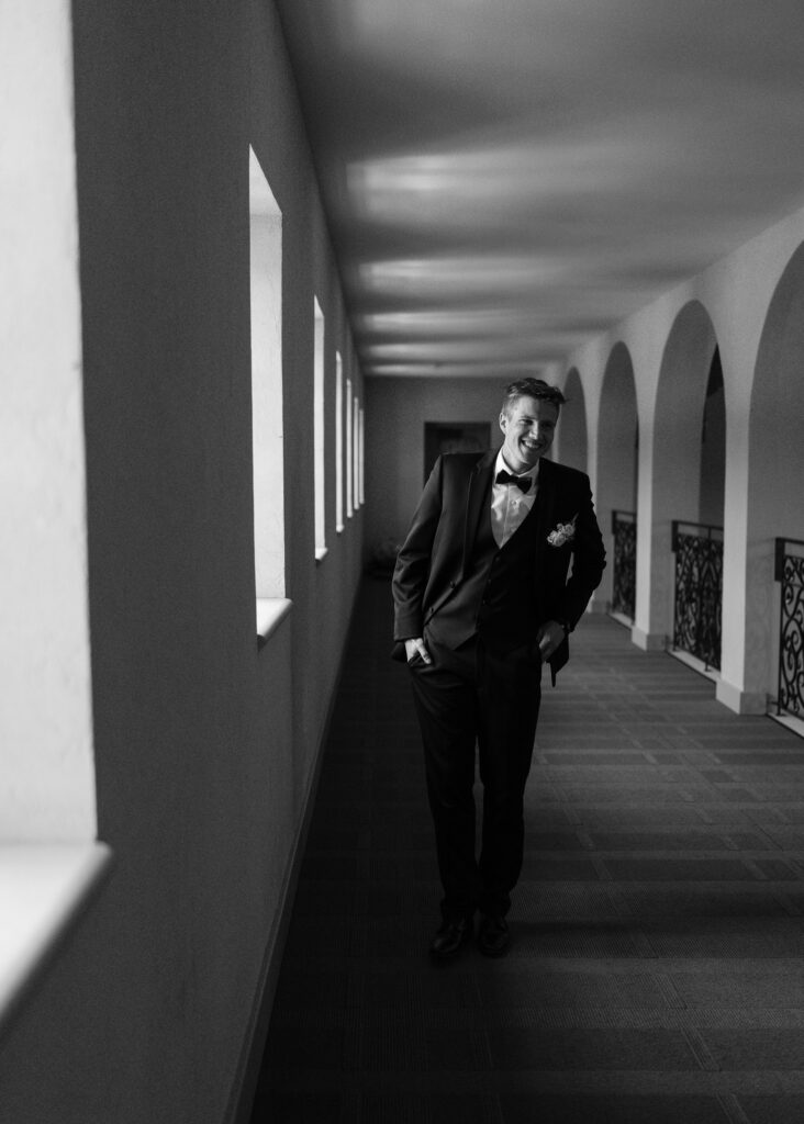 The groom adjusts his jacket as he waits for the bride for their first look.