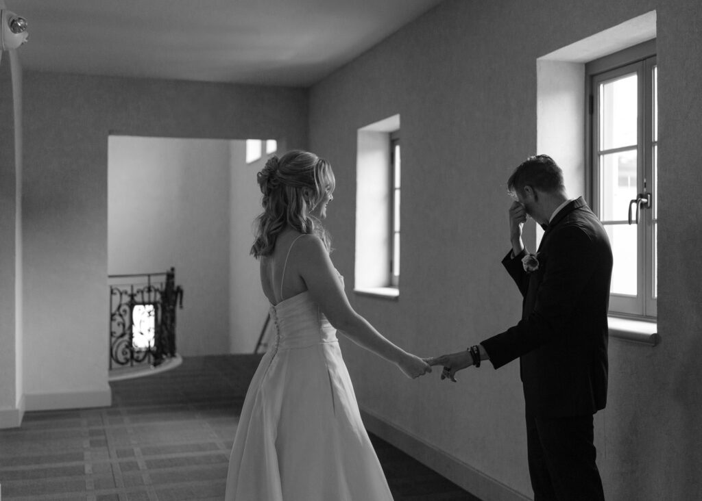 The groom wipes away a tear during the couple's first look.