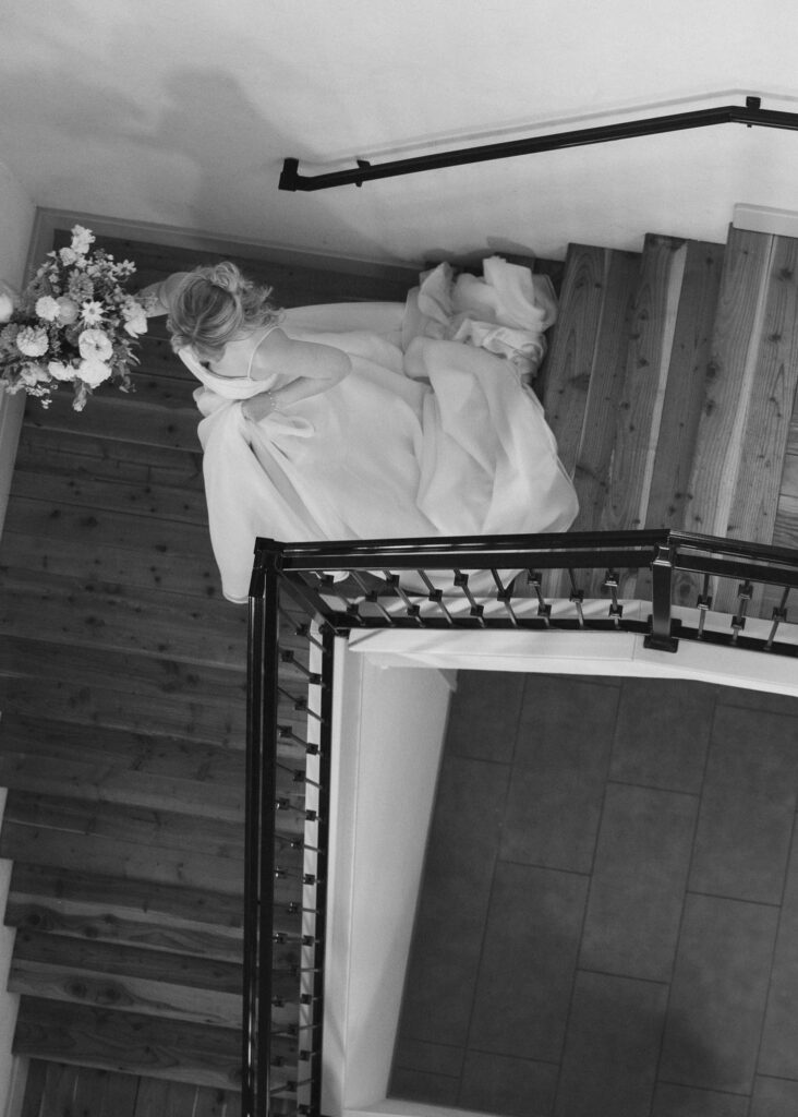 An image from above of the bride walking down a spiral staircase.