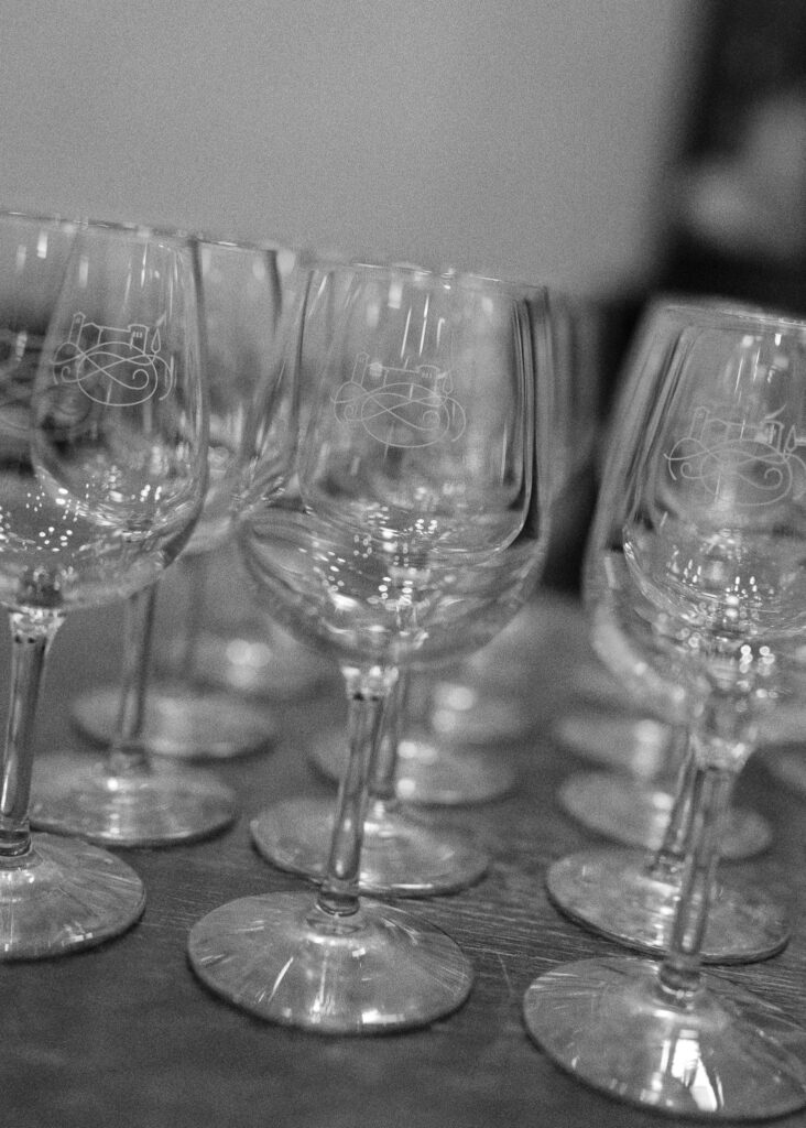 A black and white, tilted image of rows of wineglasses waiting to be filled.