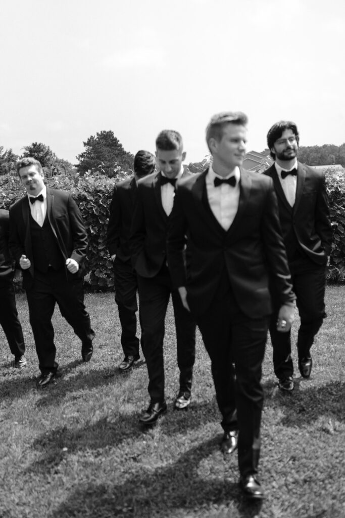 A slightly blurred image of the groom and his groomsmen walking toward the camera.