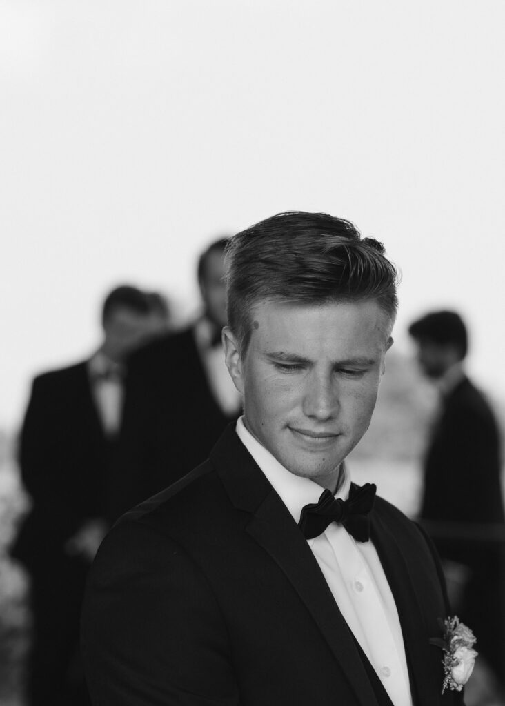 A close up of the groom's face as he waits for the bride to walk down the aisle at their wedding ceremony.