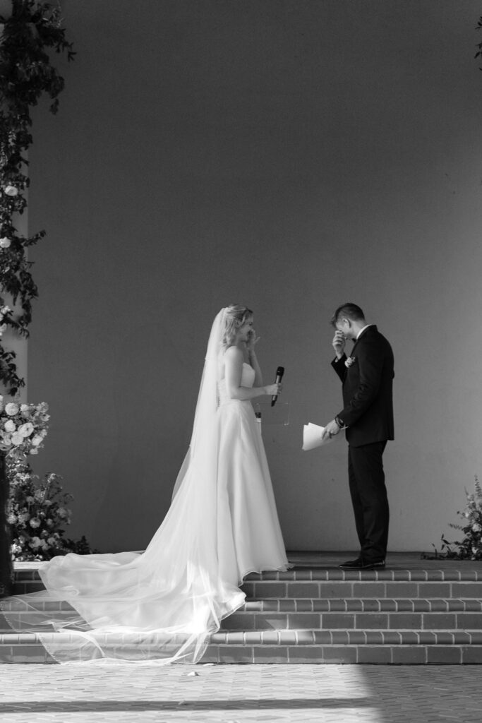 The bride and groom wipe away tears as they read their vows to one another.