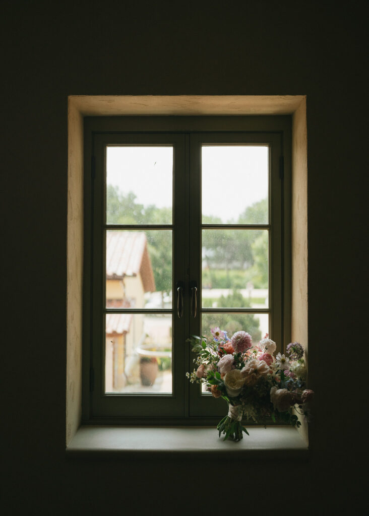 The bride's bouquet sits on a windowsill.